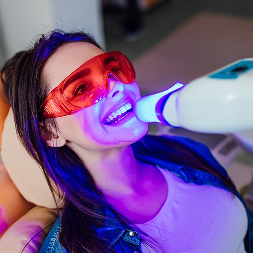 Woman receiving in office teeth whitening treatment