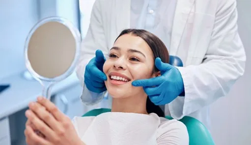 Woman smiling at reflection in handheld mirror