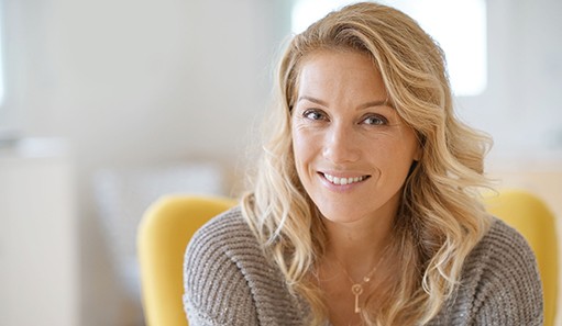 Blonde woman in grey sweater smiling