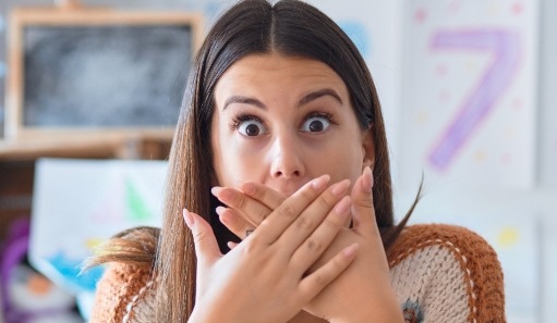 Woman with knocked out tooth covering her mouth