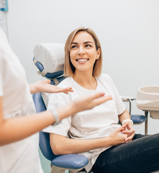 Woman in dental chair smiling at dentist