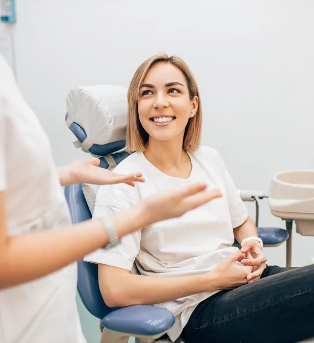 Woman in dental chair smiling at her dentist