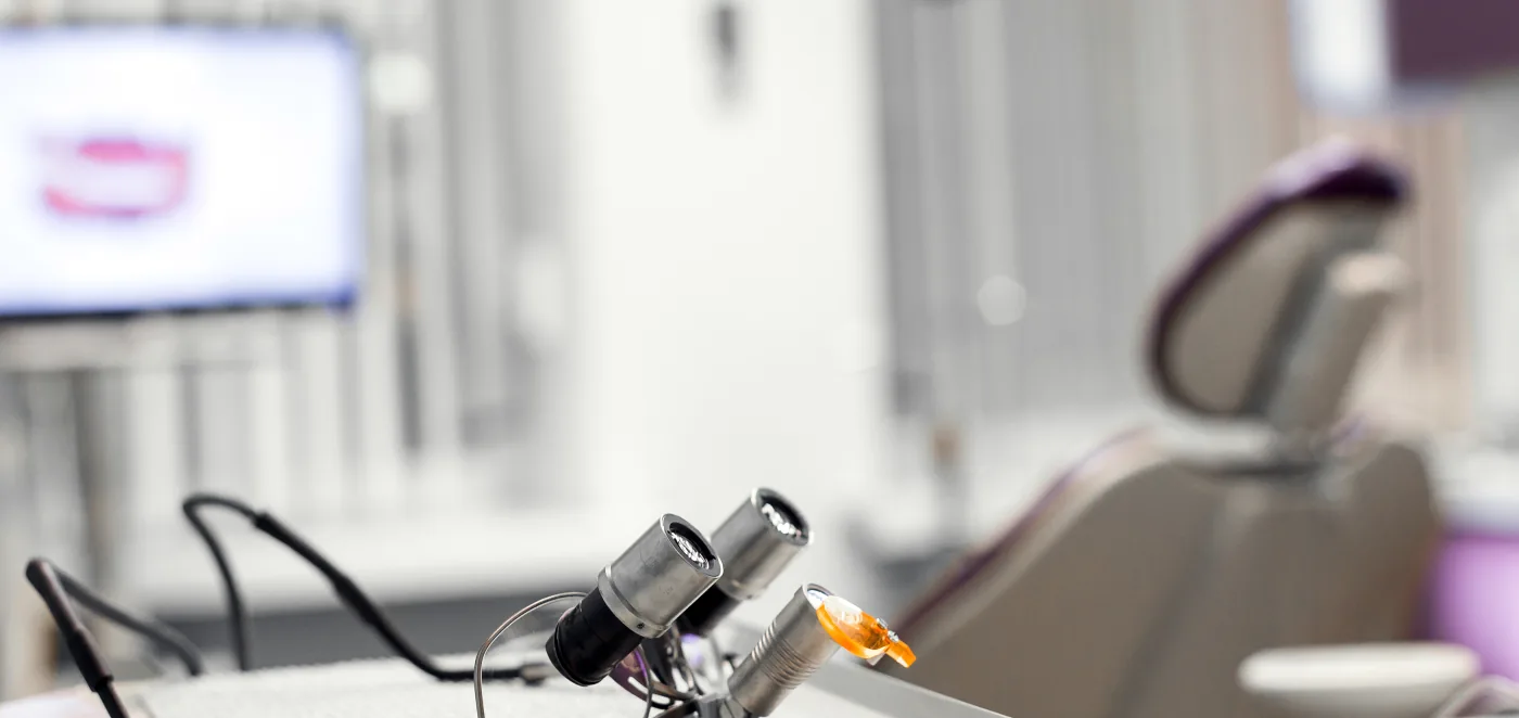 Dental treatment room with a microscope lens in the foreground