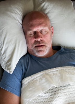 Man sleeping soundly thanks to sleep apnea treatment