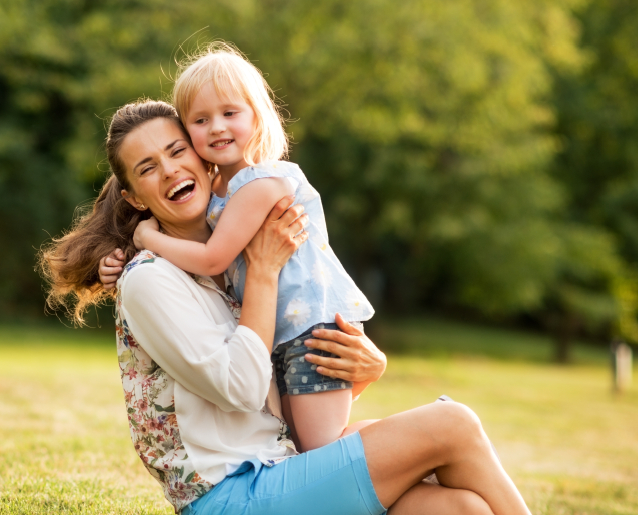 Mother and daughter smiling together outdoors