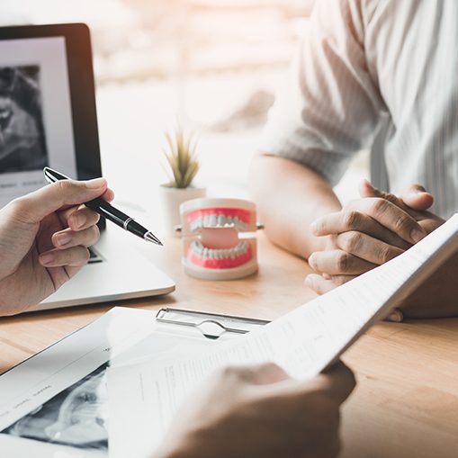 Dentist and patient reviewing dental insurance forms