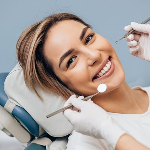 A young woman smiling in preparation for a dental checkup after completing Invisalign