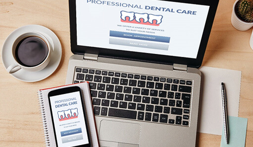 dental care form on laptop next to desk supplies and coffee