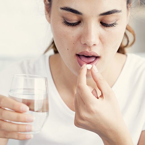 Woman taking antibiotic therapy pill