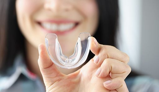 young woman holding mouthguard