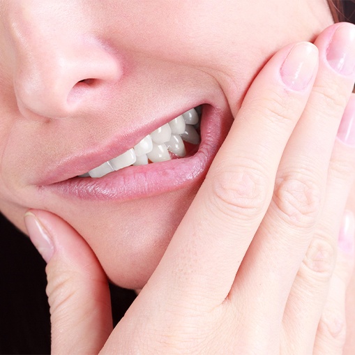 Patient in need of root canal therapy holding jaw in pain