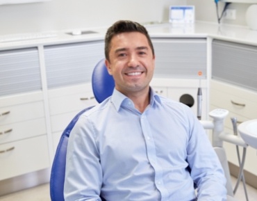 Smiling man in dental office for preventive dentistry