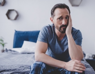 Man in need of emergency dentistry holding jaw in pain