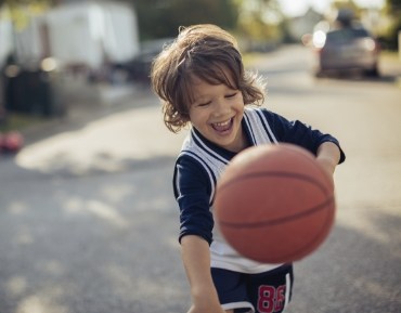 Little boy with healthy smiling playing basketball after children's denistry visit