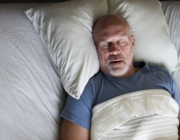 Man sleeping soundly thanks to sleep apnea therapy