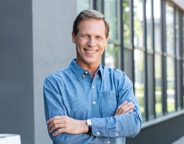 Man with flawless smile after replacing missing teeth