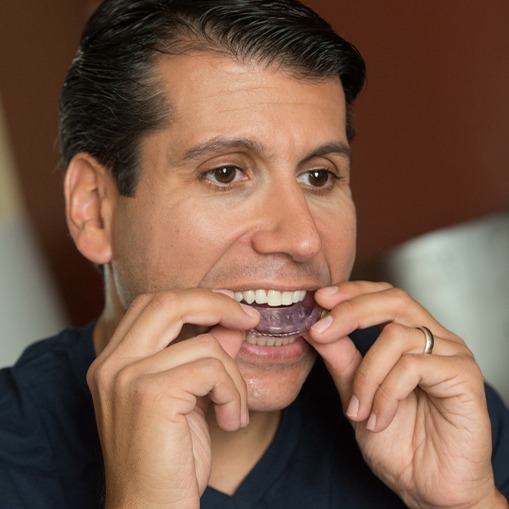 Man placing sleep apnea oral appliance