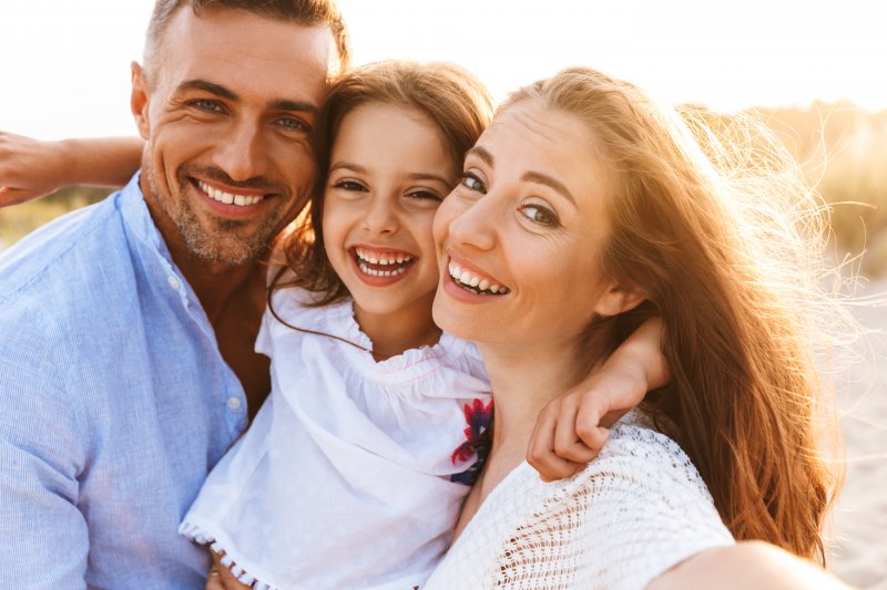 Family smiling outside