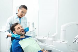 man in dental chair with dentist