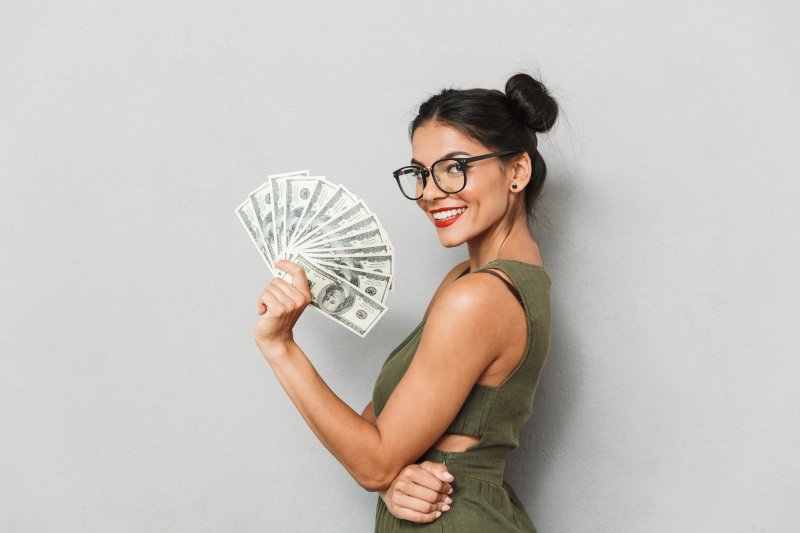 woman smiling and holding money