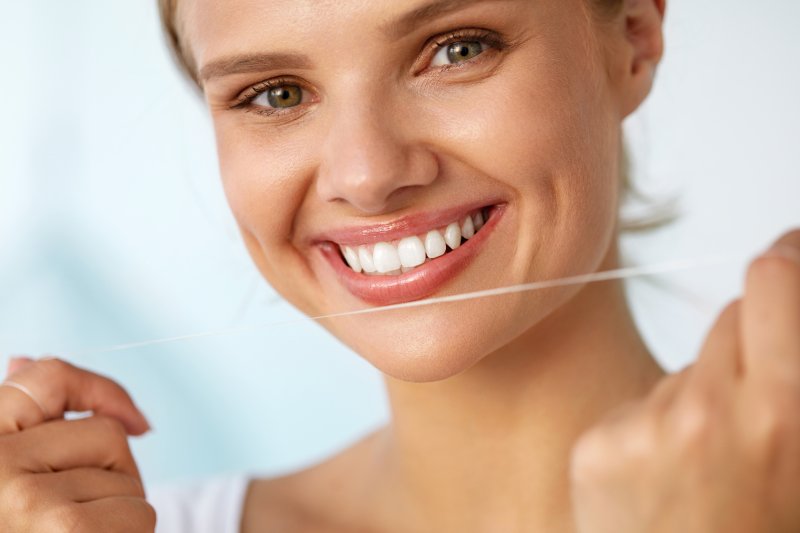 closeup of woman smiling and flossing