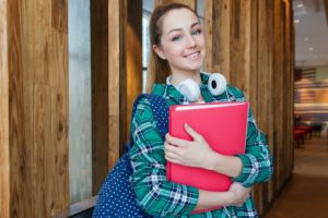 Young female student holding school folders