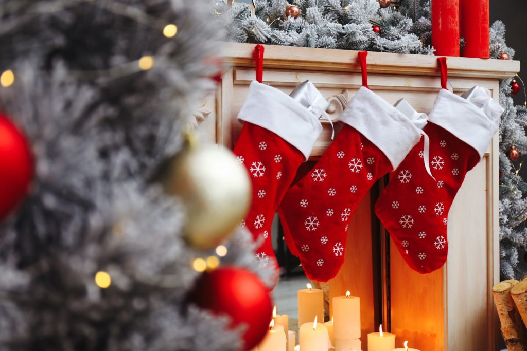 Red stockings with white snowflakes hung on fireplace with garland