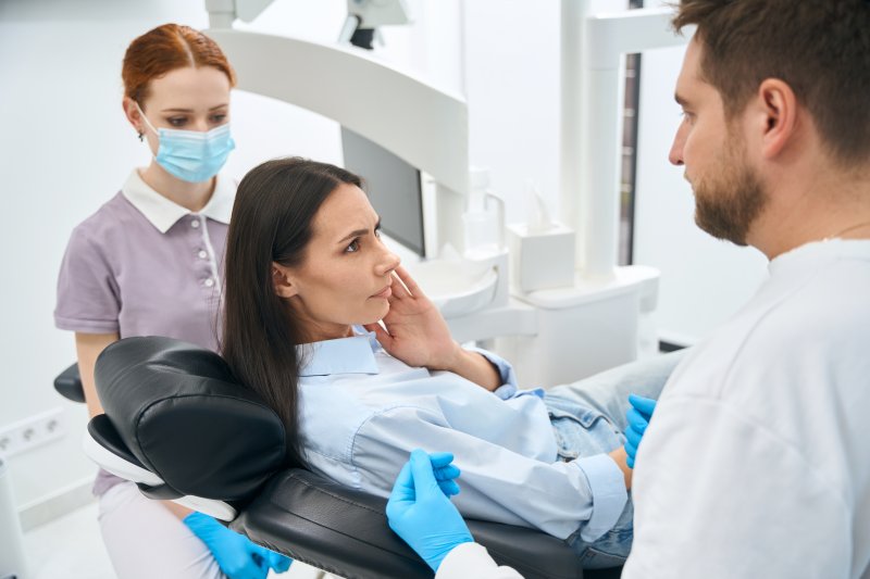 A woman with a toothache seeing her dentist