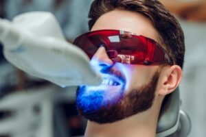 Young man having teeth professionally whitened.