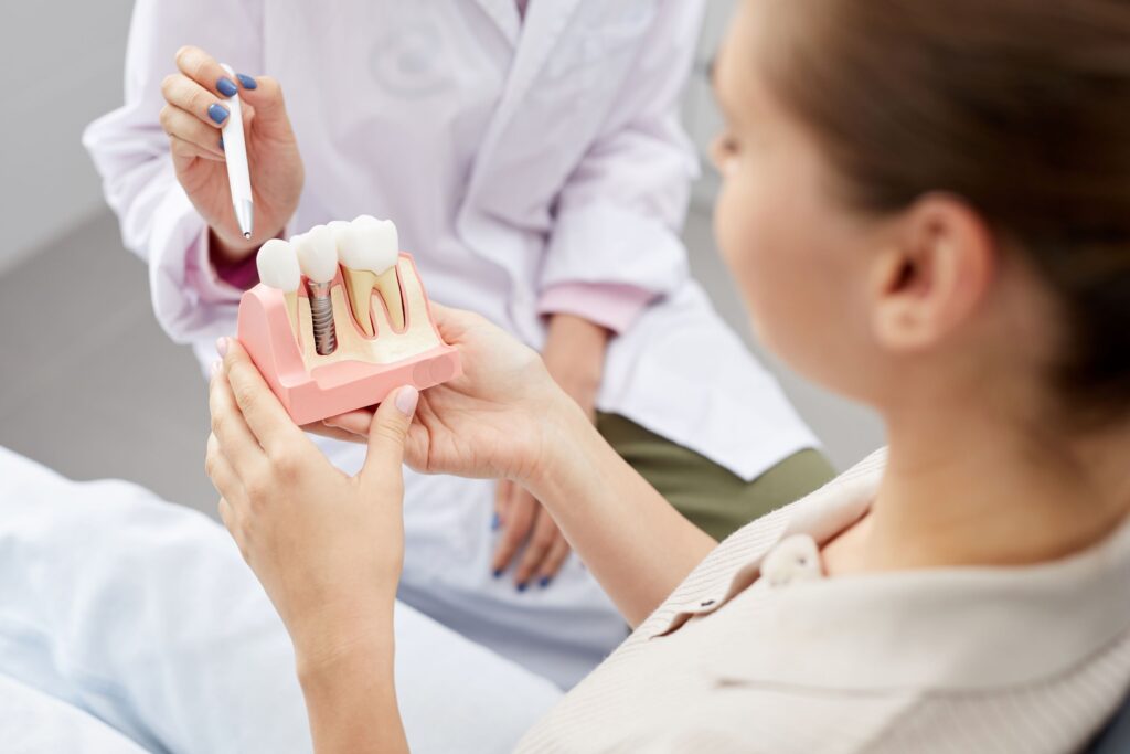 Woman holding sample dental implants